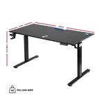 Black electric standing desk at standing height