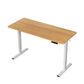 Height adjustable standing desk with an oak top and white frame