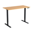 Electric sit stand desk with a natural wood top raised to standing height