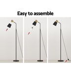 Slim black floor lamp with a metal frame and weighted base