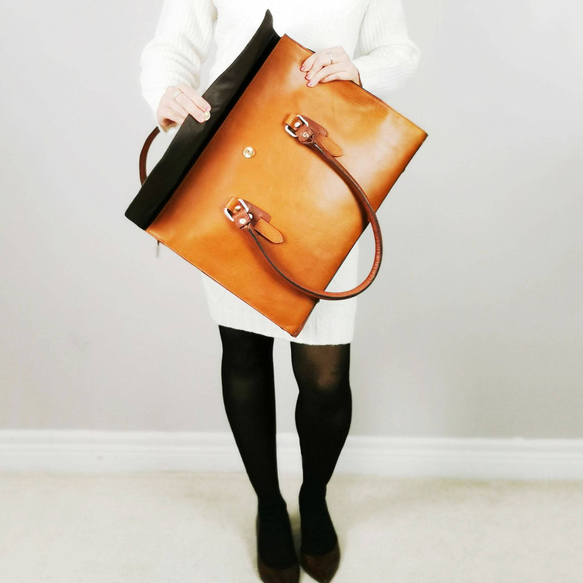 Tan leather laptop bag with a full flap closure
