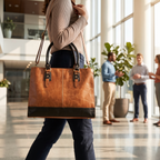 The Signature Leather Laptop Bag, Copper 17 inch — carried in an office lobby