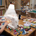 Magnifying craft lamp lighting patchwork fabric at a quilting table