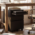 Compact black steel mobile filing cabinet tucked under a desk