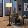 Wood and linen floor lamp beside an armchair in the evening