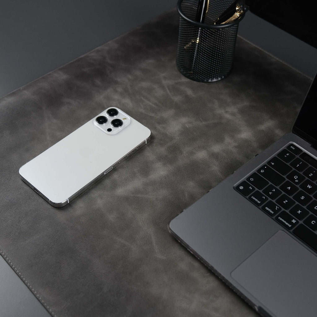Grey leather desk pad laid across a desk
